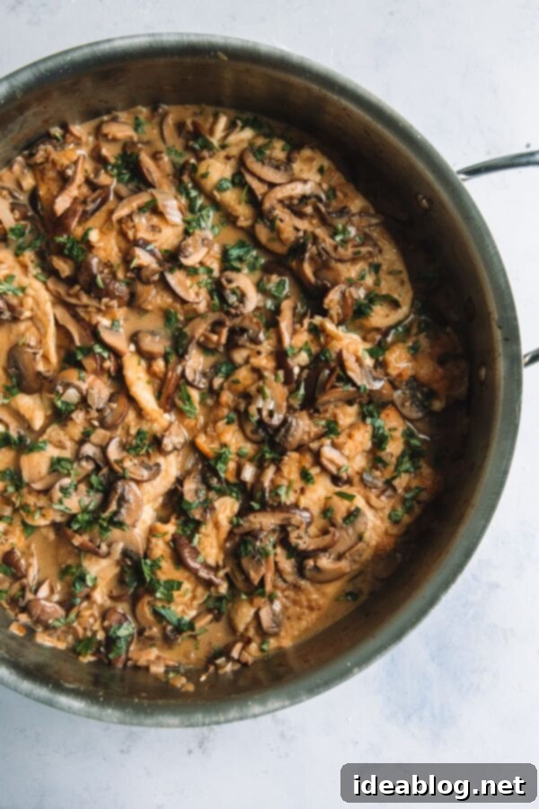 Healthier Chicken Marsala - Preparing the rich Marsala sauce with chicken. Lightened Up Chicken Marsala Simmering in a Skillet