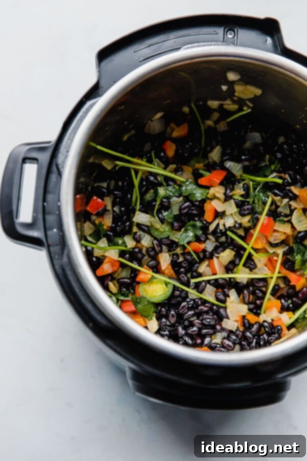 No-Soak Instant Pot Black Beans 3 Black beans and aromatic ingredients cooking in an Instant Pot.