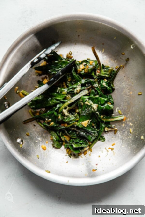 How to Cook Beet Greens - this simple sautéed beet greens recipe calls for just extra virgin olive oil, fresh garlic, red pepper flakes, and lemon zest to produce hearty, healthy greens. #abeautifulplate #beets #vegetarian #vegan #glutenfree #dairyfree #abeautifulplate #howto Sautéed Beet Greens in Skillet with Tongs