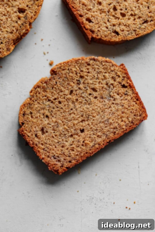 Easy HEALTHIER Banana Bread - An easy healthier banana bread recipe made with whole grain flour (all purpose will also work in a pinch!) and maple syrup for a touch of sweetness. #abeautifulplate #bananabread #easyrecipe #quickbread #recipe Slice of Healthier Banana Bread