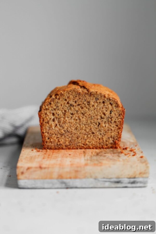 Easy HEALTHIER Banana Bread - An easy healthier banana bread recipe made with whole grain flour (all purpose will also work in a pinch!) and maple syrup for a touch of sweetness. #abeautifulplate #bananabread #easyrecipe #quickbread #recipe Banana Bread Loaf with Slice Removed