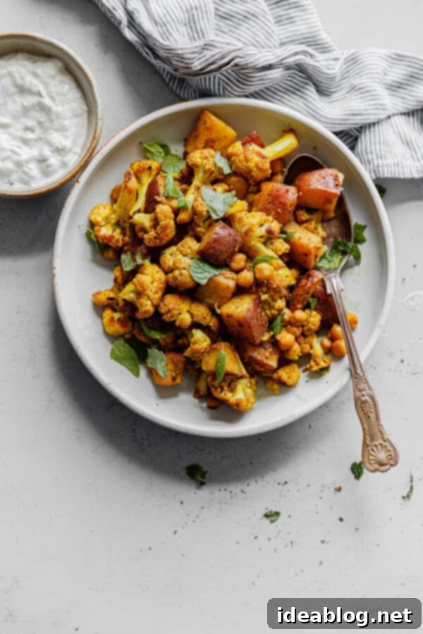 Sheet Pan Cauliflower Curry with Raita - this easy cauliflower curry, inspired by Indian Aloo Gobi, is prepared on a sheet pan and bulked up with canned chickpeas!  #vegetarian #glutenfree #curry #cauliflower #easyrecipes #sheetpan Sheet Pan Cauliflower Curry with Raita - a vibrant and easy Indian-inspired vegetarian dinner