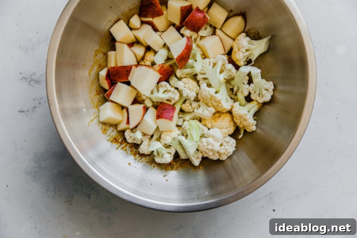 One-Pan Cauliflower Curry with Refreshing Raita 6 Potatoes and Cauliflower in Spice Mixture in Bowl