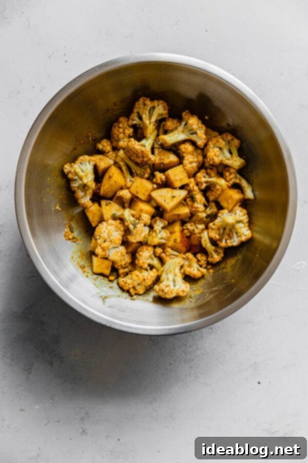 One-Pan Cauliflower Curry with Refreshing Raita 2 Roasted Cauliflower Curry Mixture in Bowl - flavorful and tender