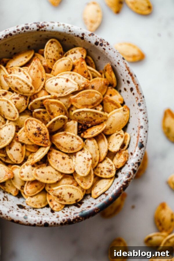 Za'atar Roasted Pumpkin Seeds - if you enjoy crunchy snacks, you'll love these easy Za'atar Roasted Pumpkin Seeds! A delicious savory twist on a classic fall staple. #abeautifulplate #pumpkinseeds #snack #fall Za'atar Roasted Pumpkin Seeds in Speckled Ceramic Bowl - A perfect savory and crunchy fall snack.
