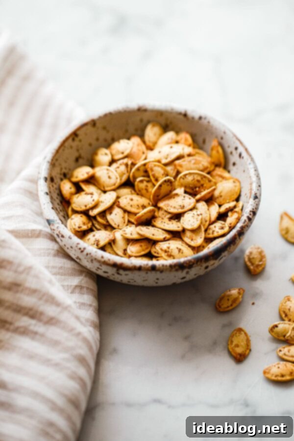 Za'atar Roasted Pumpkin Seeds - if you enjoy crunchy snacks, you'll love these easy Za'atar Roasted Pumpkin Seeds! A delicious savory twist on a classic fall staple. #abeautifulplate #pumpkinseeds #snack #fall Za'atar Roasted Pumpkin Seeds in a small ceramic bowl, ready for serving.