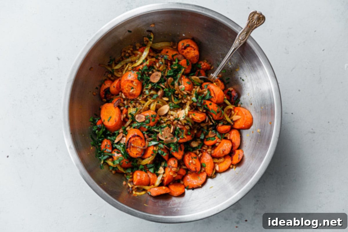 Roasted Golden Carrots with Savory Farro 14 Roasted Carrots, fresh herbs, and sliced almonds in a stainless steel bowl, after being mixed with farro and orange dressing.