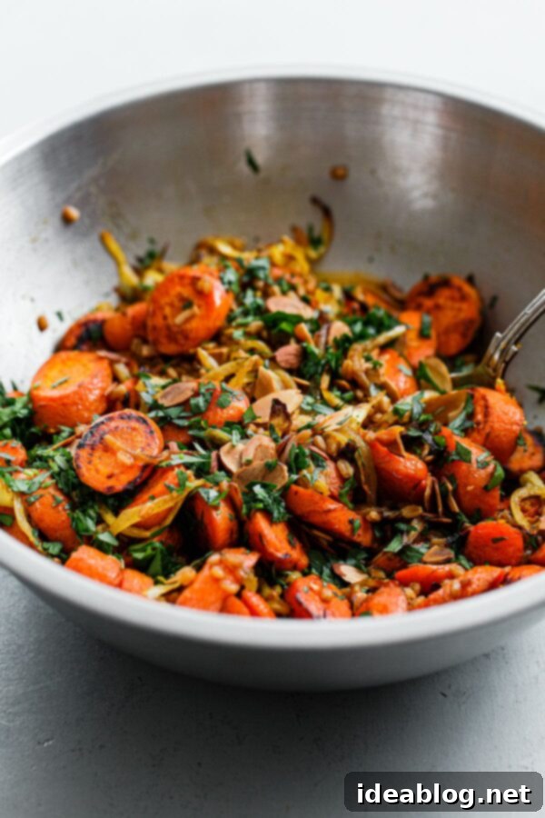 Roasted Golden Carrots with Savory Farro 4 Roasted Carrots, Herbs, and Sliced Almonds in Stainless Steel Bowl, ready to be mixed with farro.