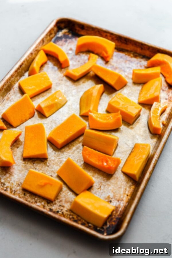 Zaatar Walnut Roasted Butternut Squash and Leeks with Orange Tahini 3 Perfectly cut butternut squash wedges arranged on a baking sheet, ready for roasting.