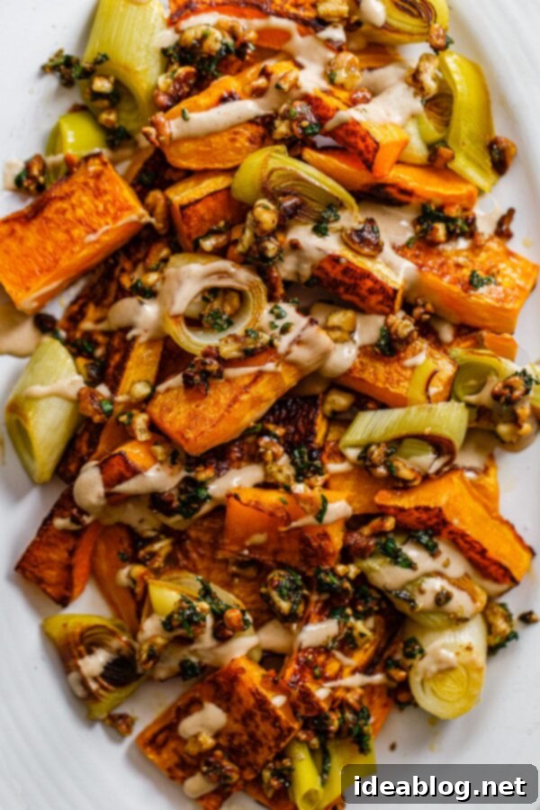 Roasted Butternut Squash and Leeks with Orange Tahini and Za'atar - a truly delicious and healthy vegetarian and vegan-friendly side dish perfect for any occasion. #butternutsquashrecipe #leeksrecipe #tahinisauce #healthyrecipes A stunning overhead shot of Roasted Butternut Squash and Leeks with Orange Tahini and Za'atar Walnut Crumble on a serving platter, highlighting its vibrant appeal.