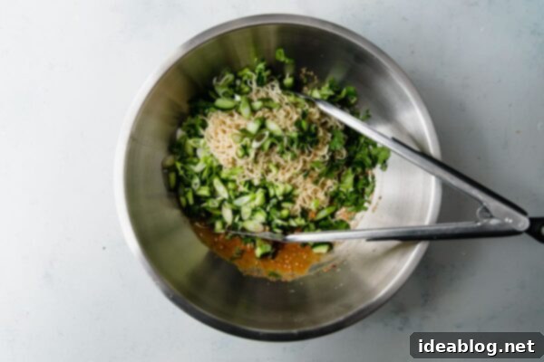 Fiery Peanut Noodles with Cool Cucumber 6 Spicy Peanut Noodles Being Mixed with Tongs