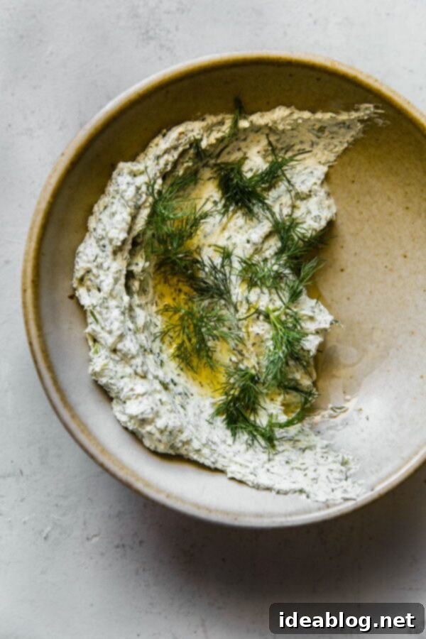 Whipped Garlic Herb Goat Cheese 2 Garlicky Herbed Goat Cheese Spread in Ceramic Bowl, served with grilled sourdough bread