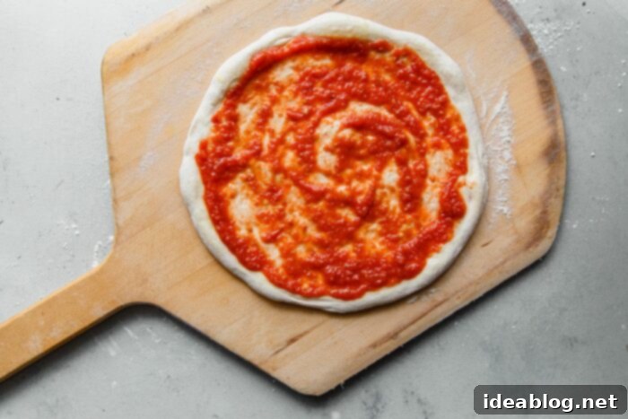 Artisan Sourdough Pizza Dough 25 Pizza Sauce Spread on Pizza Dough, creating a thin layer