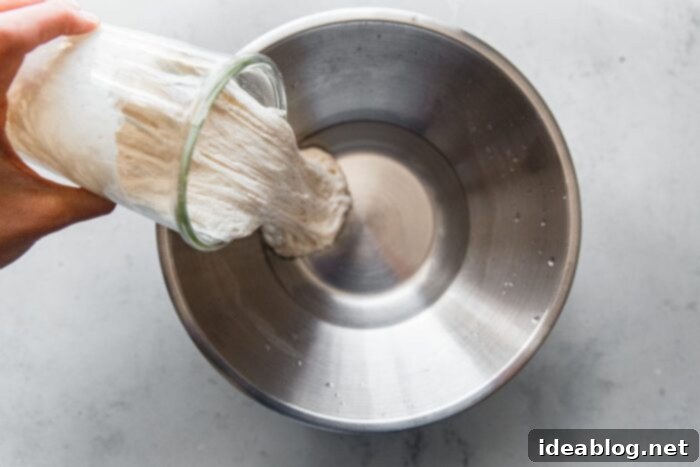 Artisan Sourdough Pizza Dough 4 Pouring Sourdough Starter into Water for Pizza Dough