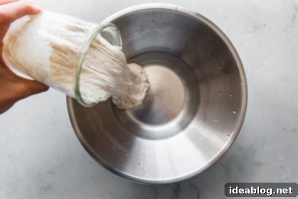Artisan Sourdough Pizza Dough 32 Pouring Sourdough Starter into Water for Pizza Dough