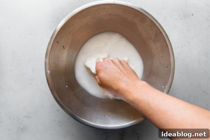 Artisan Sourdough Pizza Dough 5 Mixing Sourdough Starter into Water for Pizza Dough