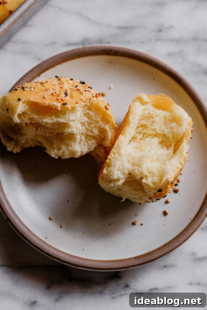 Ultimate Everything Dinner Rolls 3 A stack of fluffy dinner rolls, showcasing their soft interior and golden crust.
