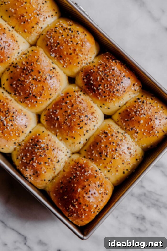 Ultimate Everything Dinner Rolls 4 Freshly baked dinner rolls topped with Everything Seasoning, glistening.