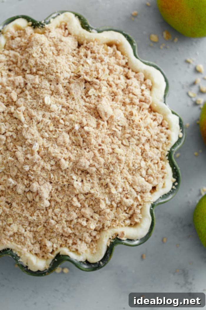 Golden Pear Crumble Delight 8 Unbaked pear pie with streusel topping evenly spread, ready for the oven