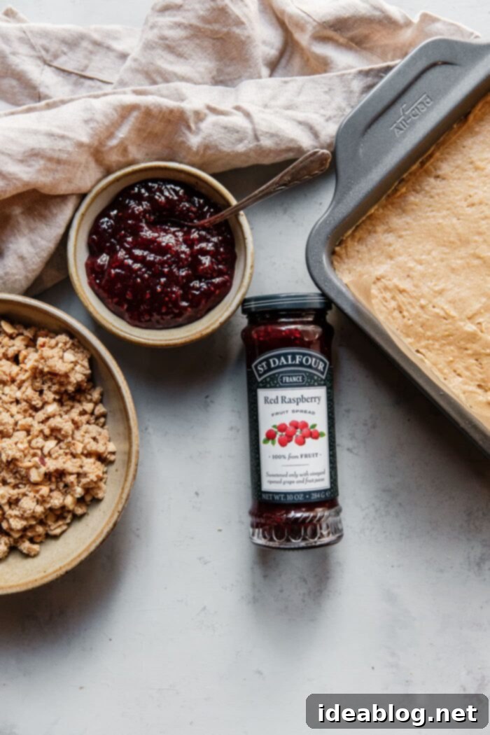 Rustic Raspberry Hazelnut Crumb Bake 12 Spreading the cake batter evenly into the parchment-lined baking pan.