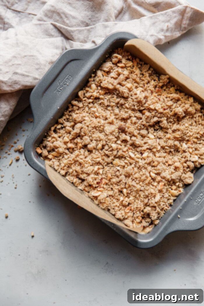 Rustic Raspberry Hazelnut Crumb Bake 16 The baked Hazelnut Raspberry Crumb Cake, golden brown with a rustic crumb topping, cooling in its pan.