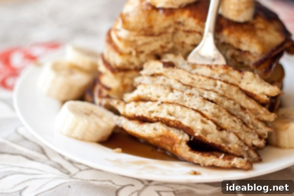 Tropical Banana Pancakes with Golden Coconut Caramel 6 Close-up of a stack of banana pancakes with coconut caramel syrup and banana slices