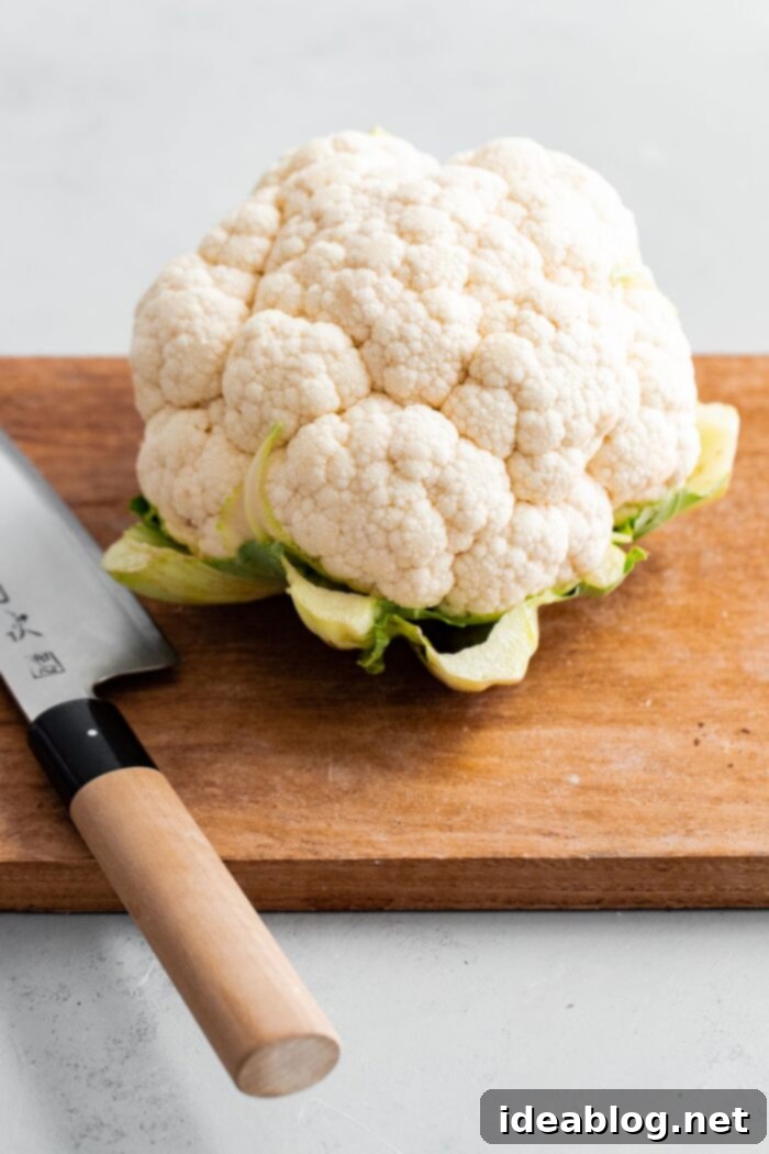 Golden Roasted Cauliflower with Zesty Tahini Mint Drizzle 2 Cauliflower on a cutting board, ready for florets