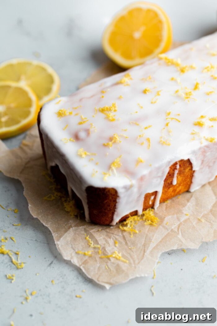 Zesty Lemon Loaf 3 Close-up of a glazed lemon loaf cake, showing the rich, buttery texture and glistening tart lemon glaze.
