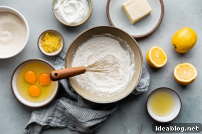 Zesty Lemon Loaf 4 Ingredients for a buttery and moist lemon loaf cake, highlighting fresh lemons and other baking essentials.