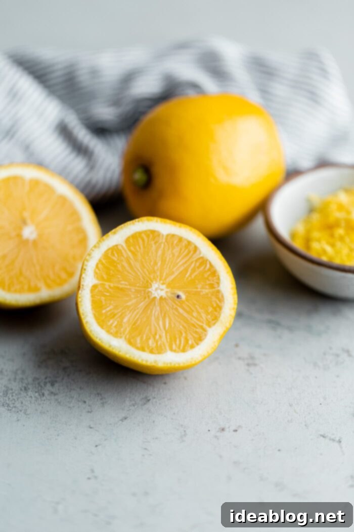 Zesty Lemon Loaf 5 Freshly sliced lemons and grated lemon zest, ready for baking the perfect lemon loaf cake.