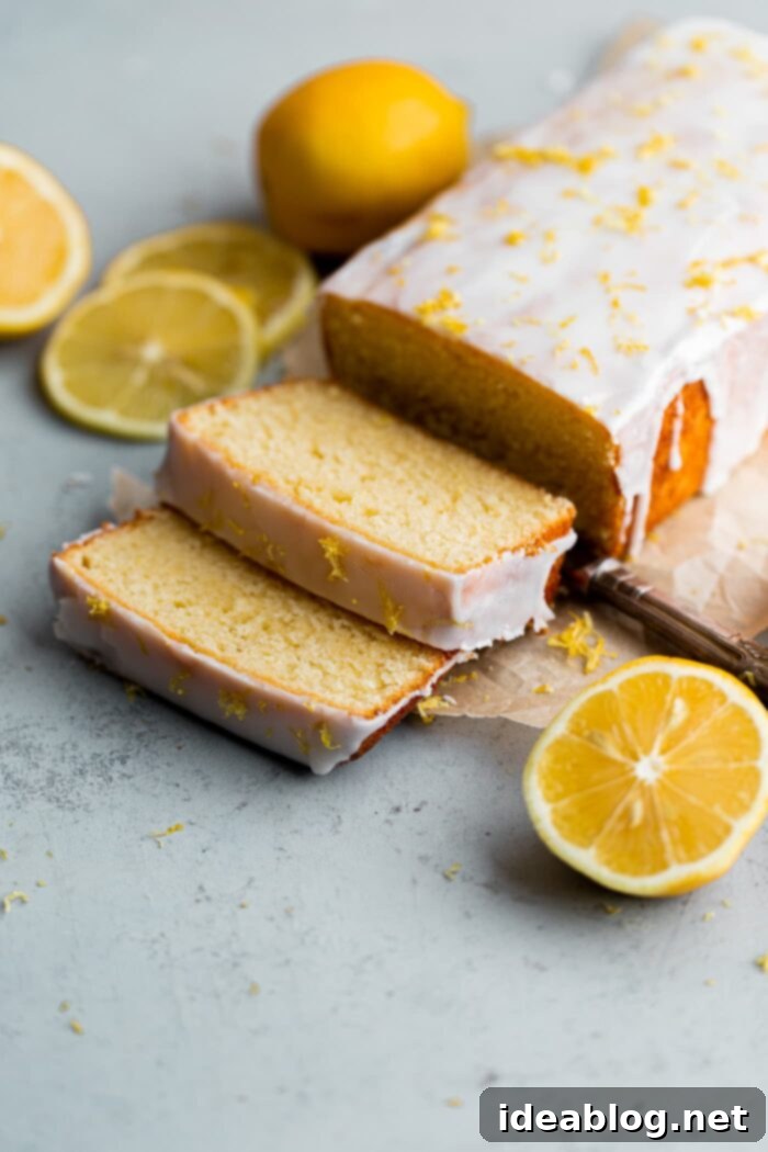 Zesty Lemon Loaf 7 A perfectly sliced portion of lemon loaf cake, revealing its moist crumb and thick, tart lemon glaze.