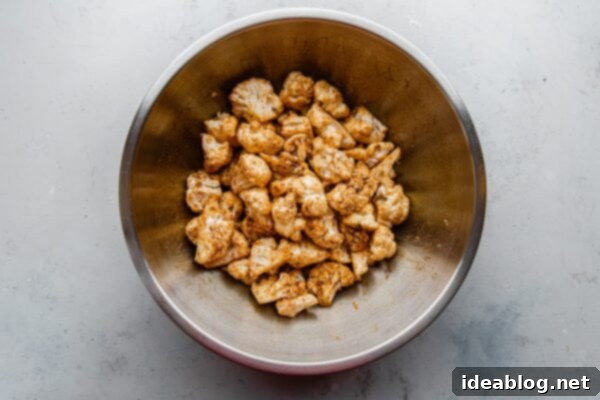 Roasted Cauliflower with Warm Spices 12 Cauliflower florets tossed with spices in a bowl, showing even coating