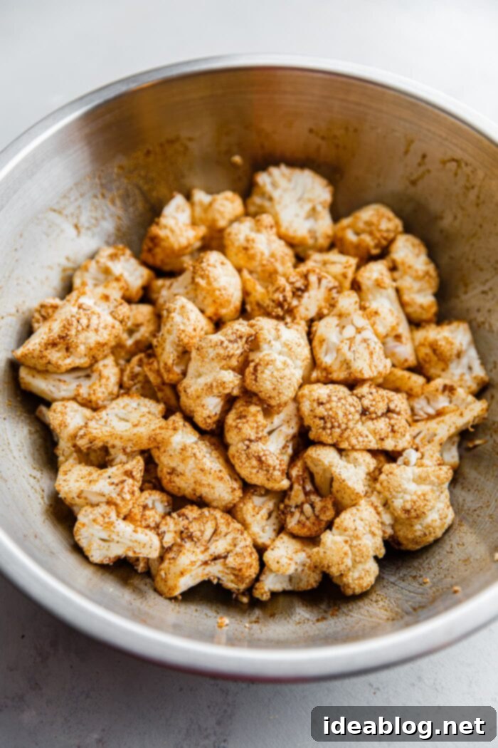 Roasted Cauliflower with Warm Spices 7 Spiced cauliflower florets arranged in a single layer on a baking sheet, showcasing proper spacing