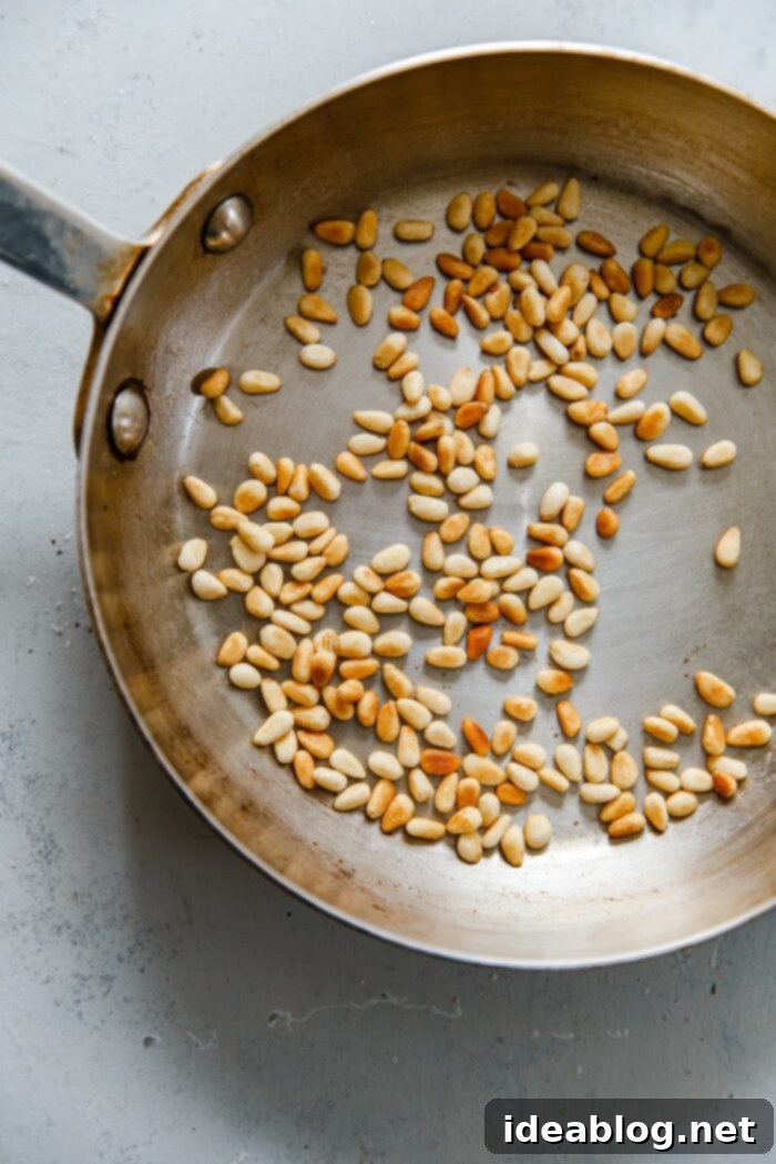 How to Perfectly Toast Pine Nuts 7 Pine Nuts Achieving a Golden Brown in a Hot Skillet, Being Stirred