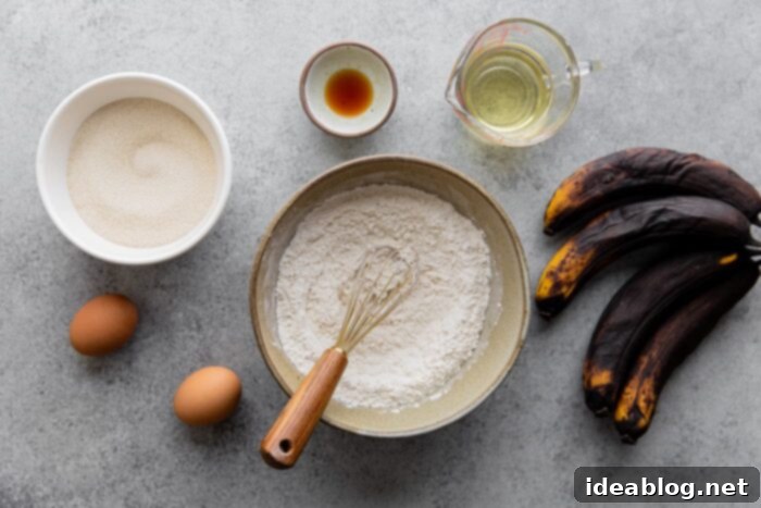 Ultimate Moist Banana Bread 6 All the essential ingredients for moist banana bread laid out on a kitchen counter: flour, bananas, eggs, oil, sugar, vanilla, baking soda, salt, nutmeg, and turbinado sugar.