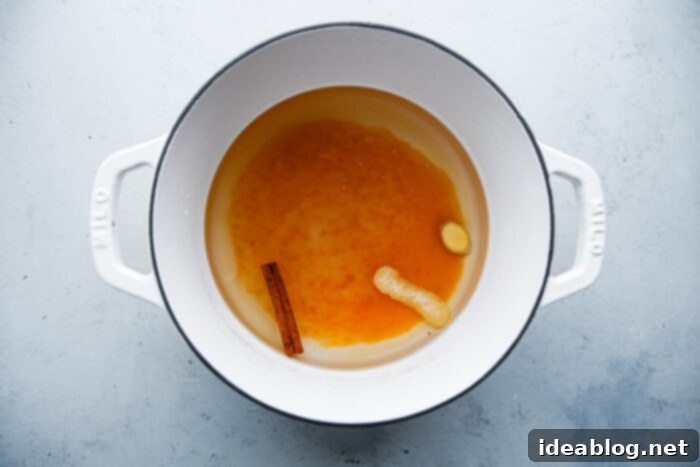 Silken Poached Quince 6 Poaching liquid with spices simmering in a saucepan