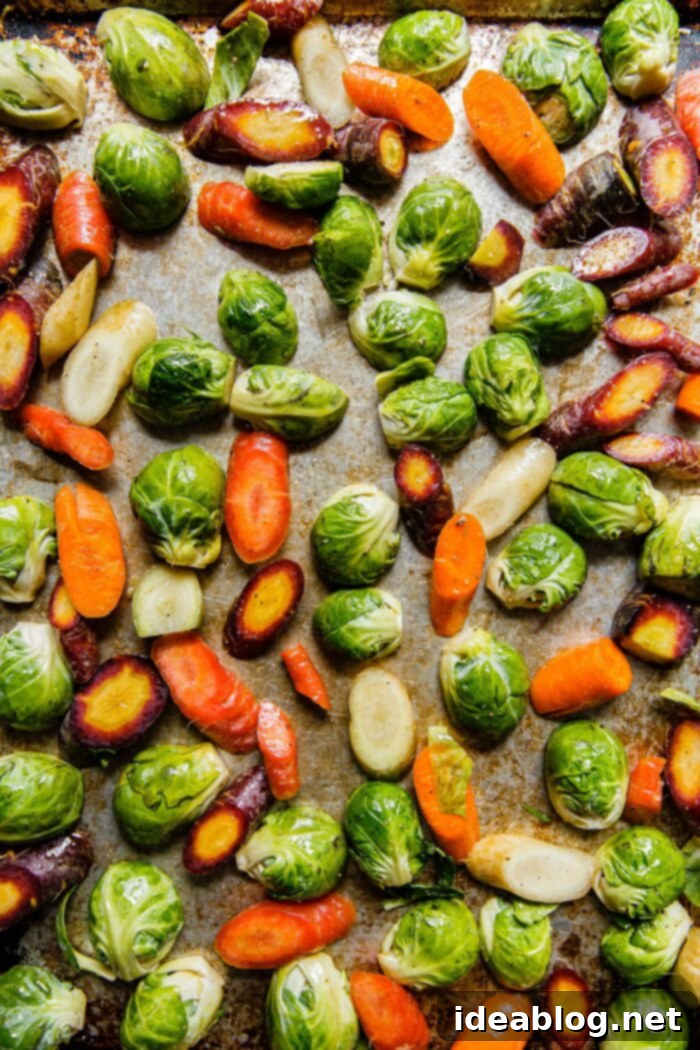 Autumn Harvest Farro Bowl 3 Sheet pan with prepped Brussels sprouts and tri-color carrots, seasoned and ready for roasting