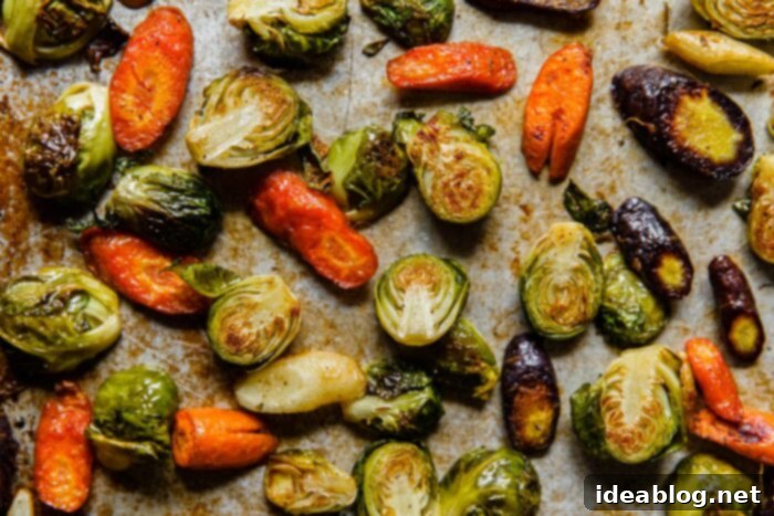 Autumn Harvest Farro Bowl 5 Close-up of golden-brown roasted Brussels sprouts and carrots on a baking sheet