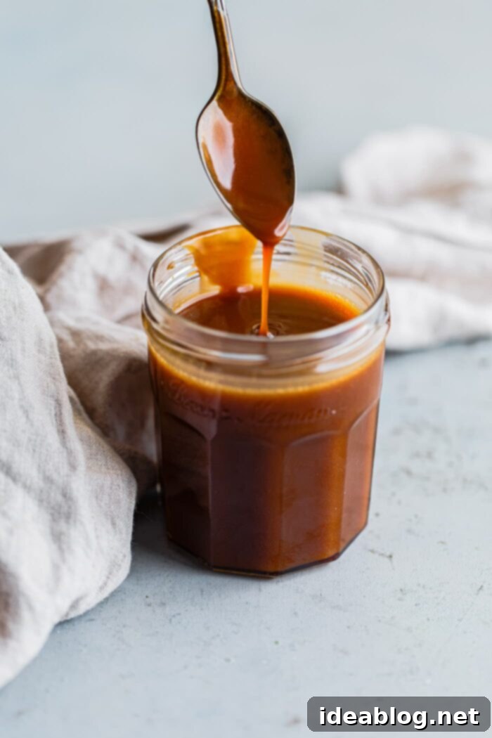Spirit Infused Caramel Indulgence 2 Salted Bourbon Caramel Sauce dripping from a spoon onto dessert