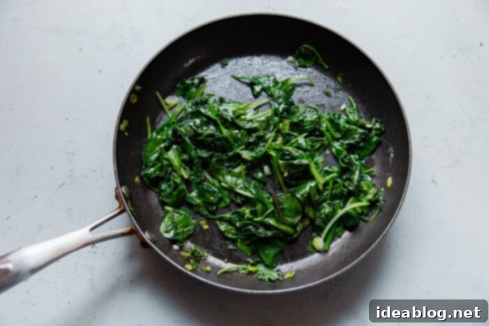 Fluffy Cheesy Eggs with Fresh Greens 7 Sautéed greens with scallions in a skillet, gently cooked