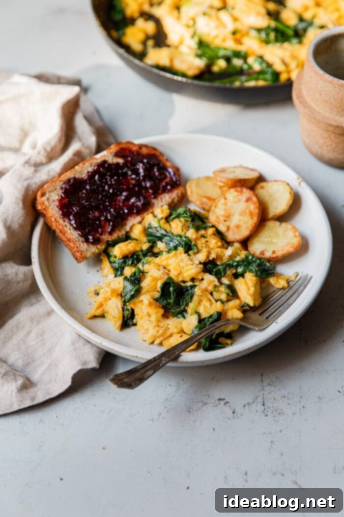 Fluffy Cheesy Eggs with Fresh Greens 9 Plated Cheesy Scrambled Eggs with Greens, toast, and potatoes