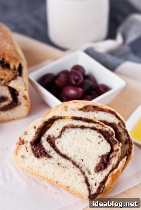 Artisan Olive Tapenade Swirl Bread 8 Close-up of a rustic slice of Olive Tapenade Swirl Bread, showing the intricate tapenade pattern