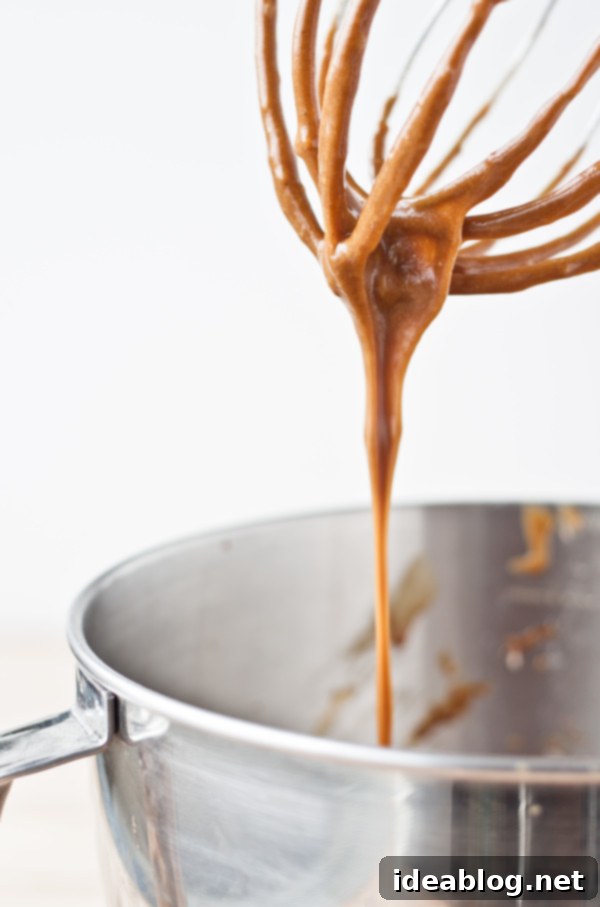 Pomegranate-Kissed Gingerbread Clouds 4 Gingerbread cupcake batter being expertly mixed in a stand mixer with a whisk attachment, showcasing its smooth consistency