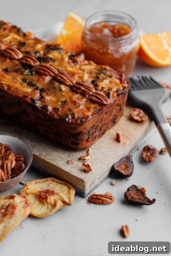 A traditional moist fruit cake made with rum soaked dried fruit, citrus zest, and candied ginger. The best fruit cake recipe you’ll ever make! #abeautifulplate #holiday #christmas #fruitcake #cake #recipe Moist Fruit Cake Topped with Whole Pecans and Apricot Glaze