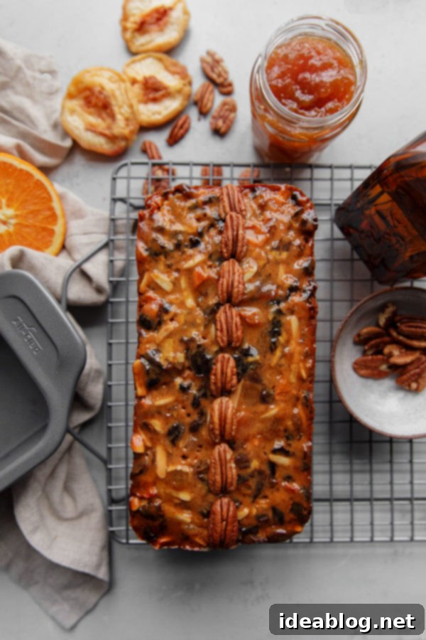 A traditional moist fruit cake made with rum soaked dried fruit, citrus zest, and candied ginger. The best fruit cake recipe you’ll ever make! #abeautifulplate #holiday #christmas #fruitcake #cake #recipe Fruit Cake on Baking Rack