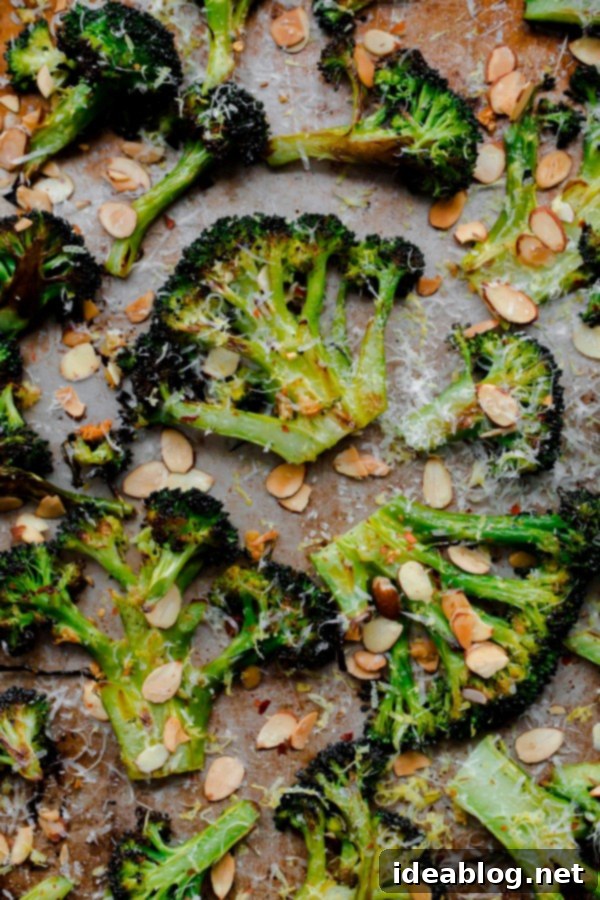 Effortlessly Delicious Roasted Broccoli 5 Roasted broccoli 'steaks' with almonds on a sheet pan, ready to be tossed with lemon and pecorino.